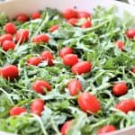 Add tomatoes and agugula to salad bowl