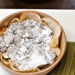 Place corn tortillas in bowl and set with tinfoil. Bake.